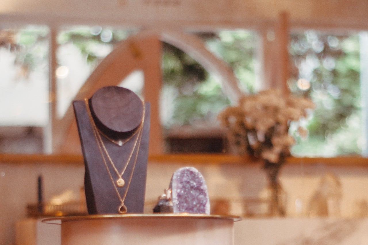 A trio of pendants sit on a necklace display at a jewelry store.