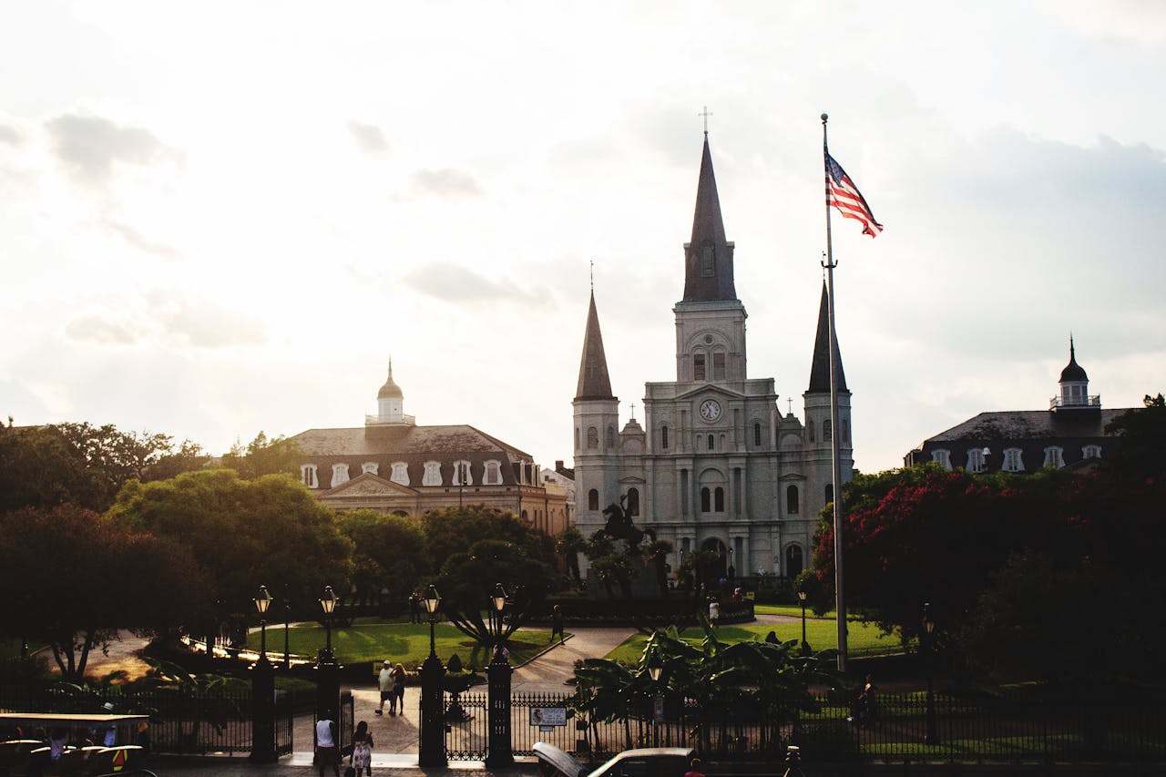A wide view of the cathedral and garden in Jackson Square on a bright day.