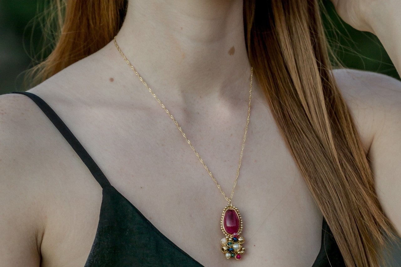 A woman wearing a custom gemstone pendant
