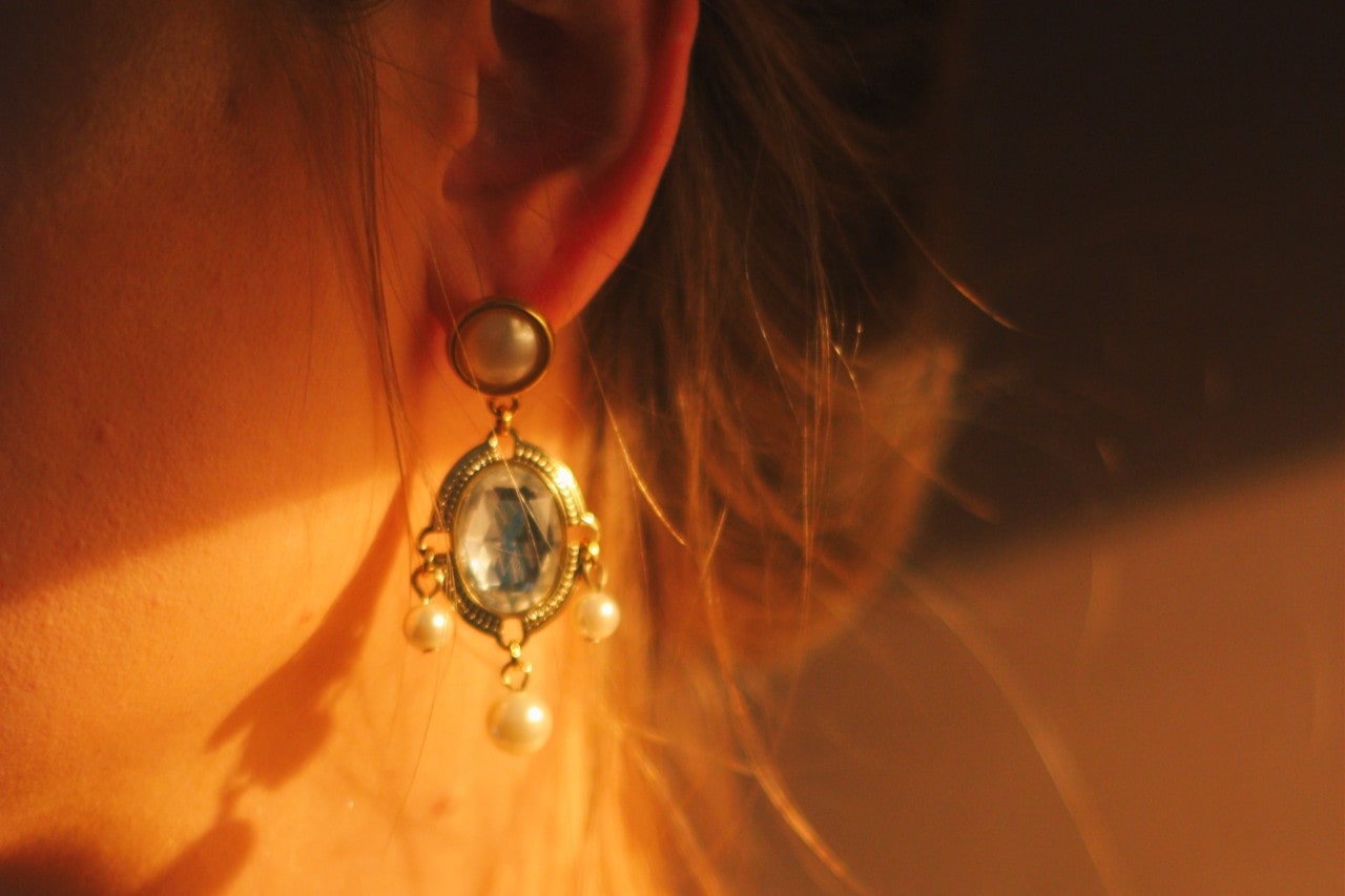 Aquamarine and pearl drop earring being worn by a woman