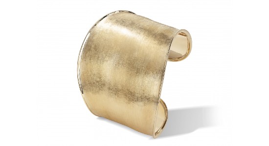 a large, bold gold cuff bracelet with a unique finish