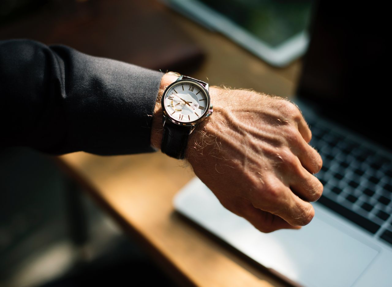 Man who may or may not be someone’s dad checking the time on their watch.