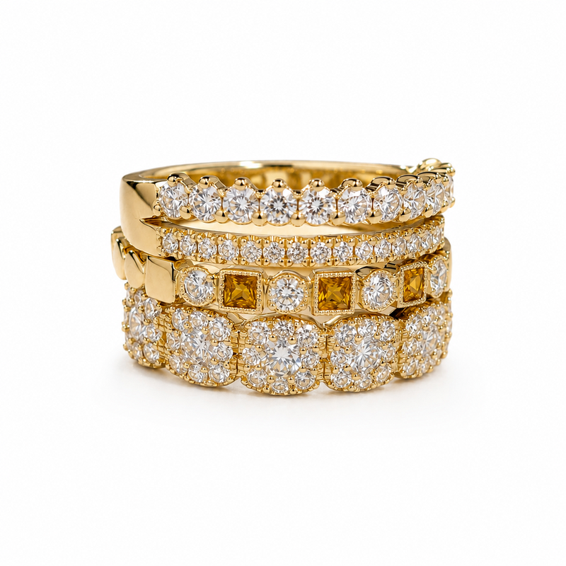 Three wedding bands stacked on top of a large men’s wedding band.