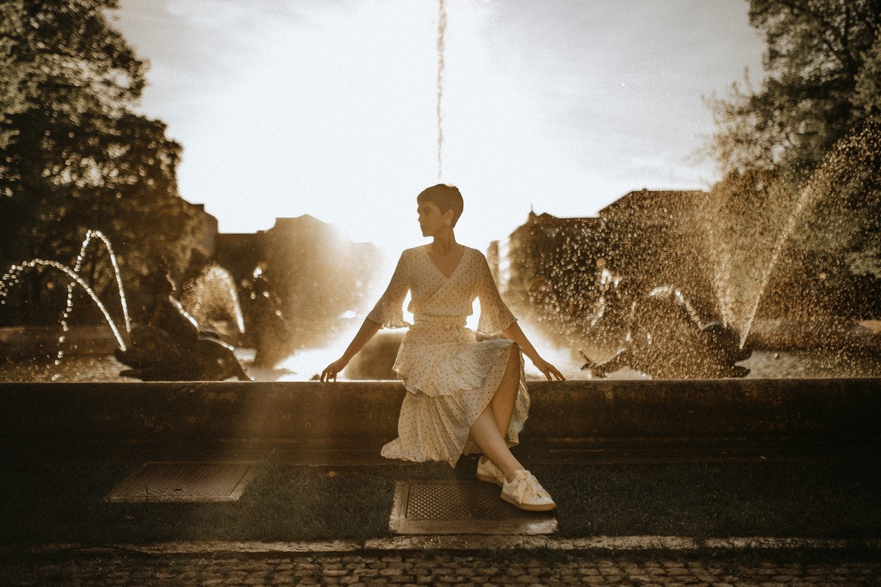 Woman seating front of the fountain Woman seating front of the fountain