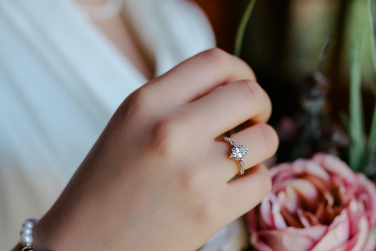 A close up of a bride’s marquise cut engagement ring with delicate details.