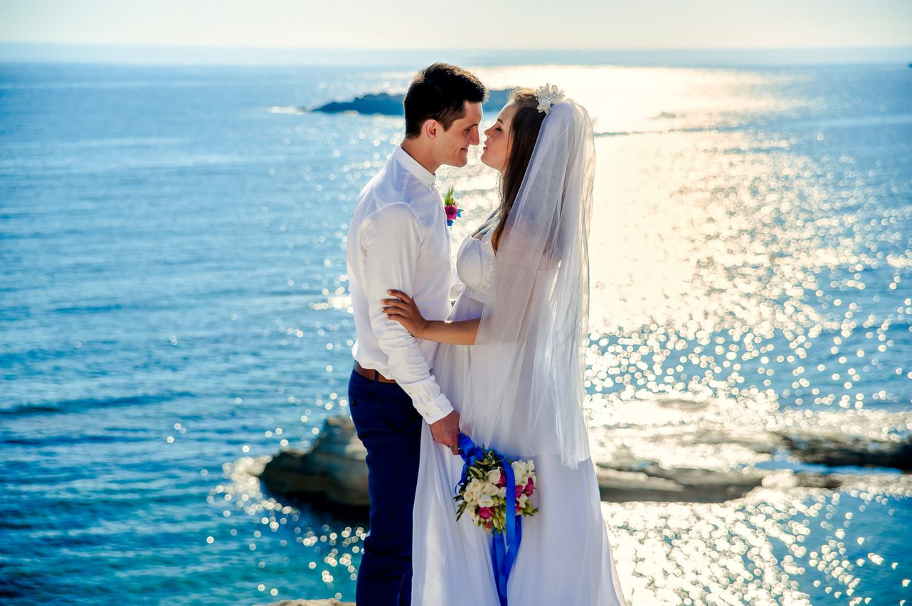 bride and groom embracing with an oceanic background