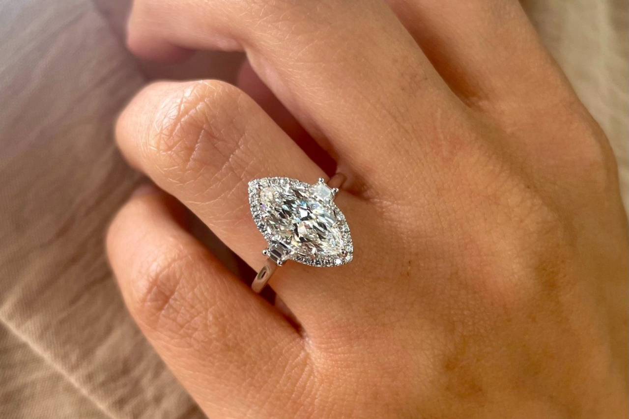a woman’s hand placed on her cheek and donning an engagement ring