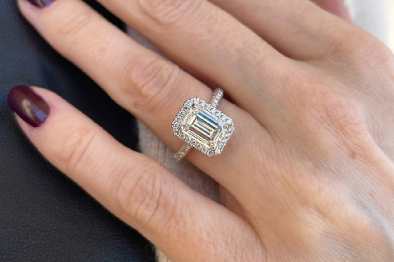 a bride placing her fingers on her chin and wearing an engagement ring between two bands