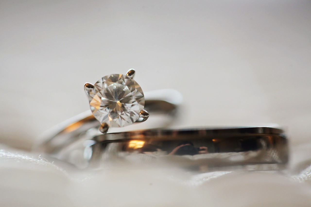a solitaire engagement ring resting up against a wedding band