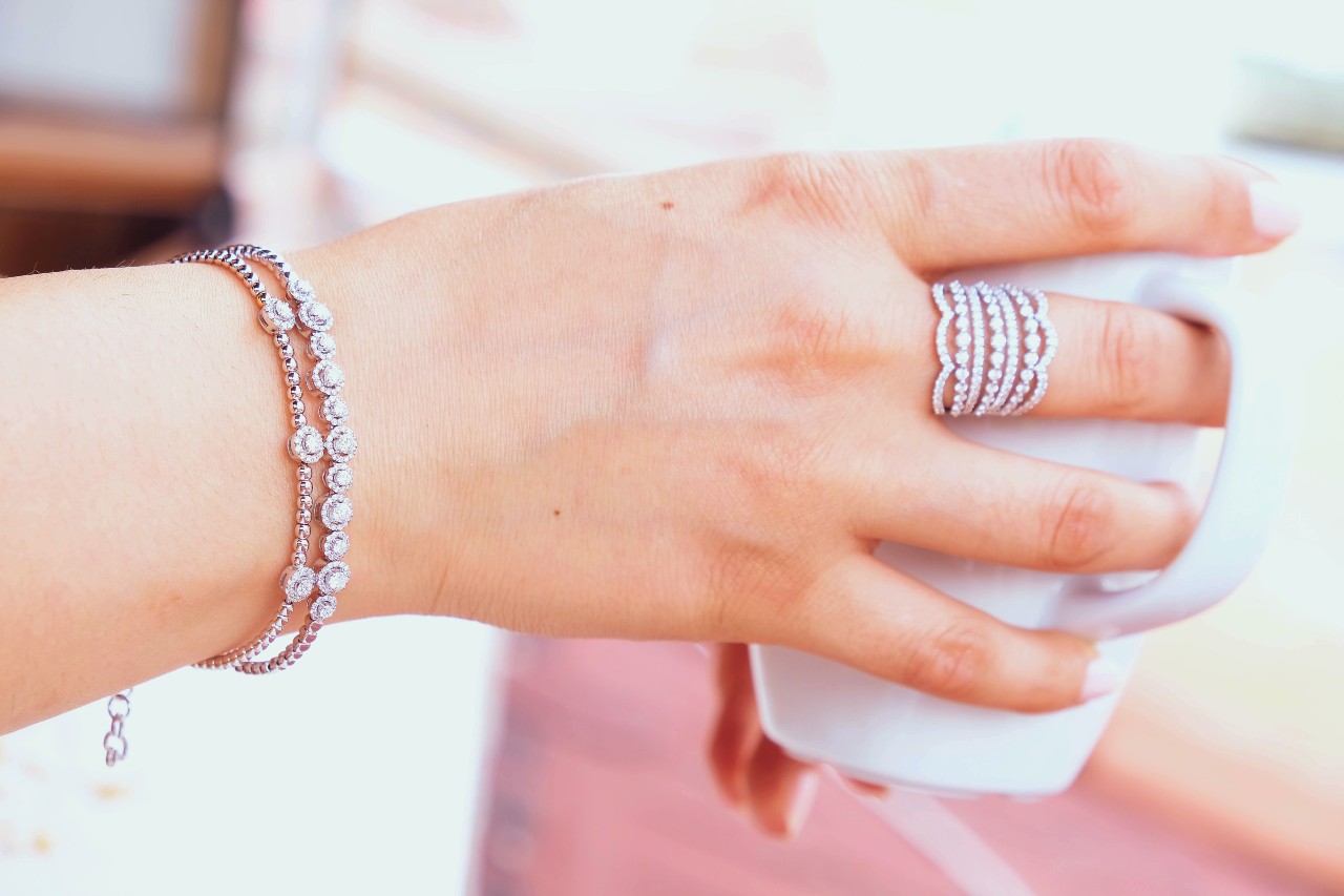 Close-up shot of a woman’s hand holding a white mug, featuring delicate silver jewelry on her finger and wrist. Close-up shot of a woman’s hand holding a white mug, featuring delicate silver jewelry on her finger and wrist.